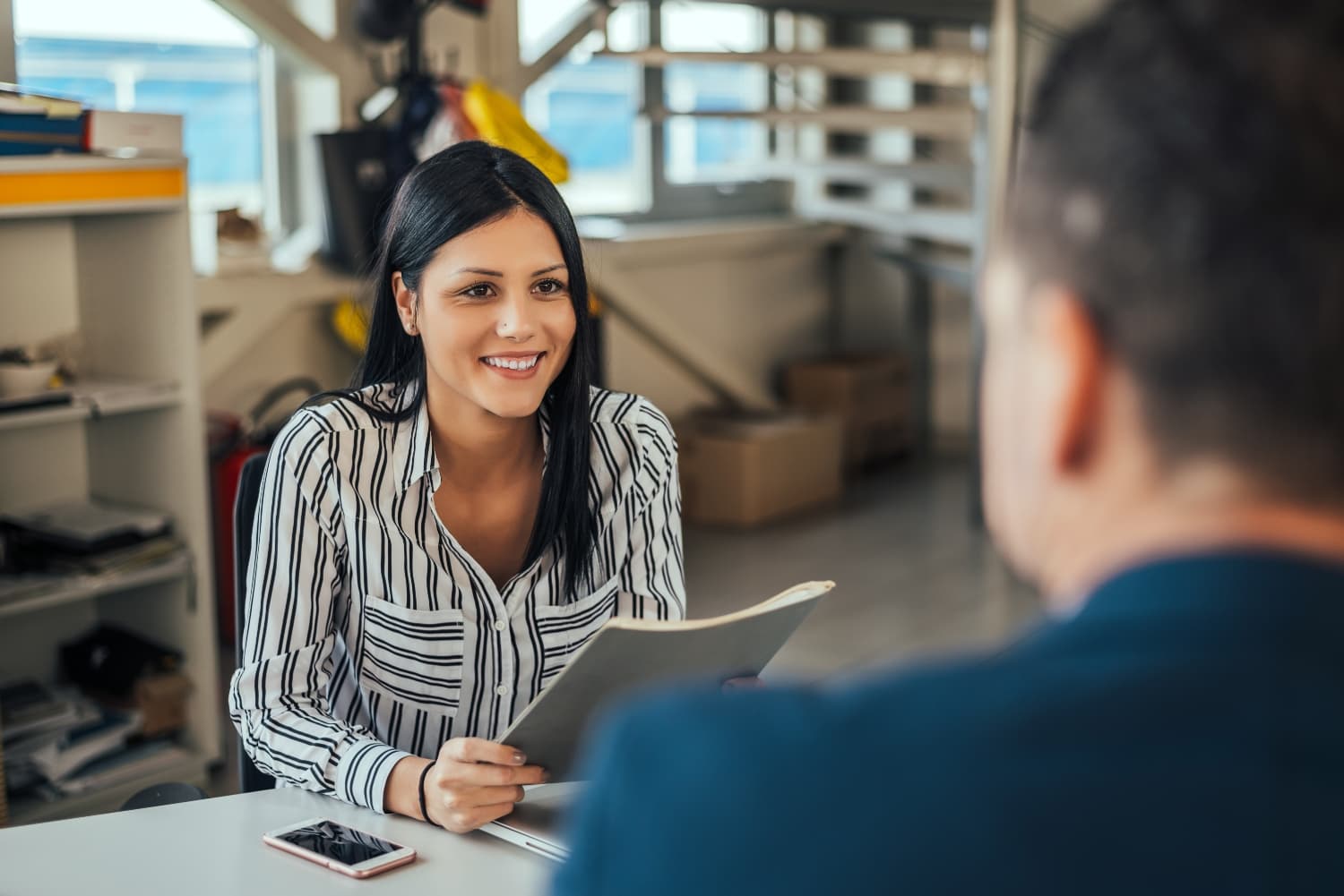 Two people talking at a desk